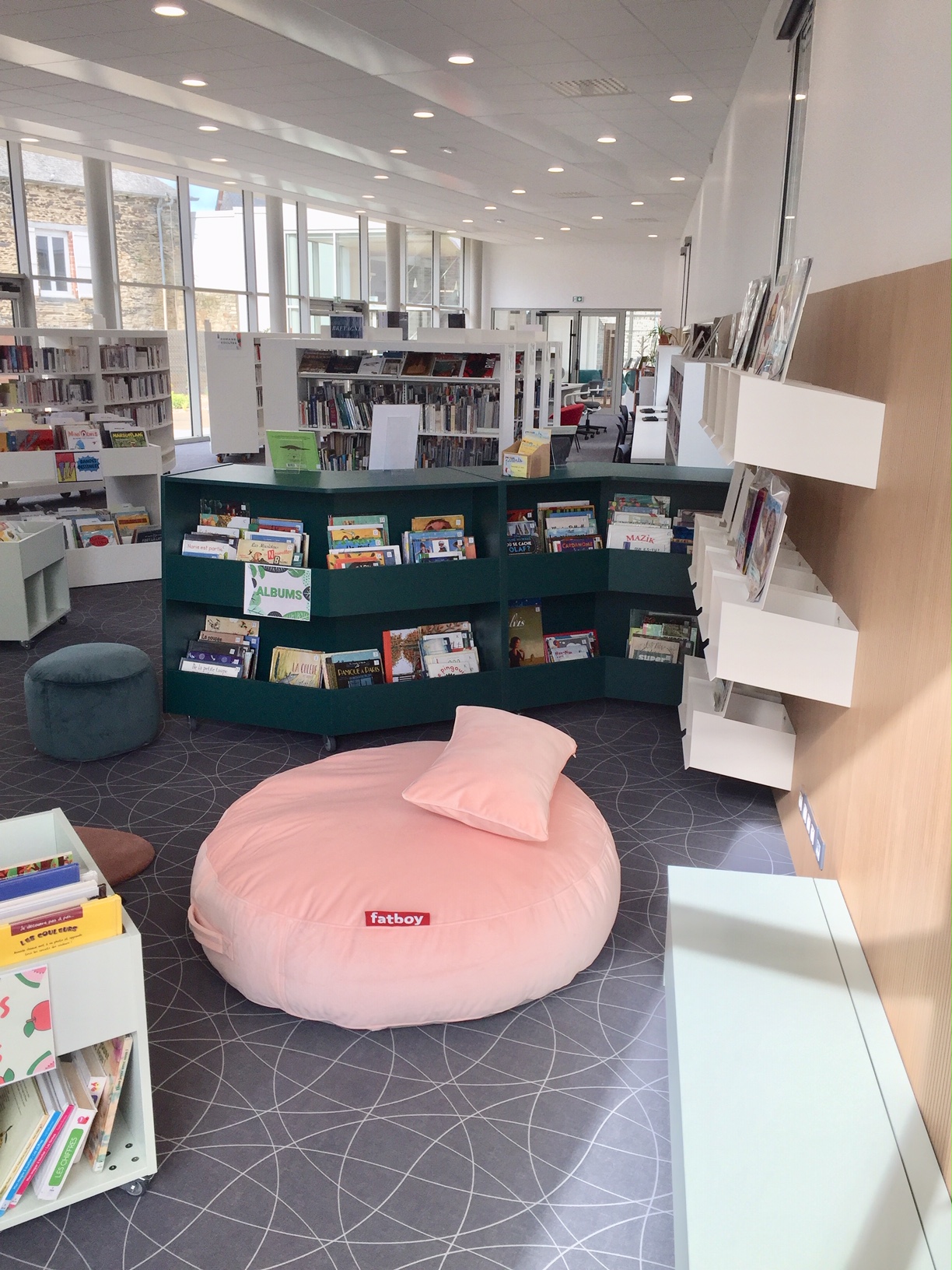 Espace jeunesse de la médiathèque avec tapis et bacs à albums